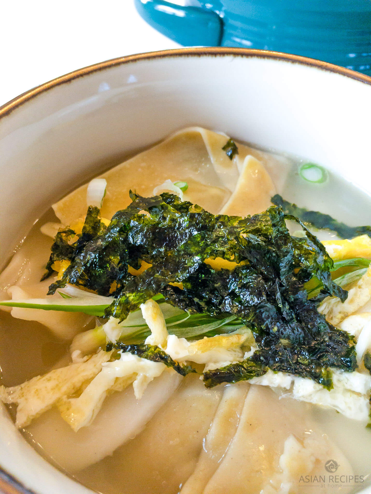 Korean rice cake soup is a savory and delicious soup made of sliced rice cakes and dumplings in a clear broth.