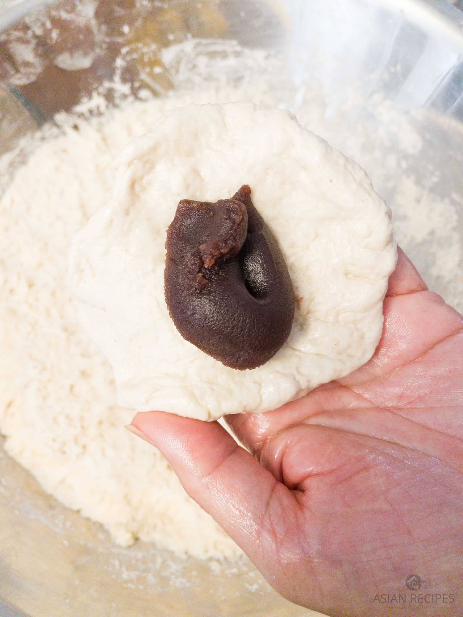 Making homemade steamed buns with sweet red bean paste.