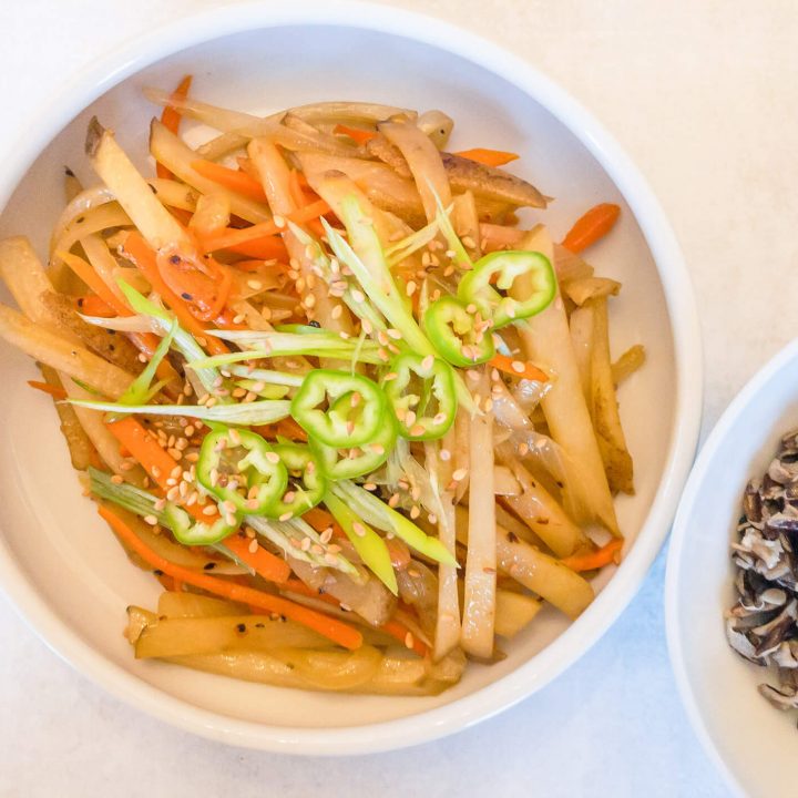 Our Whole30 Korean-style Stir-fried Potatoes recipe is made with julienne potatoes stir-fried with onions and carrots for a delicious and umami-filled side dish.