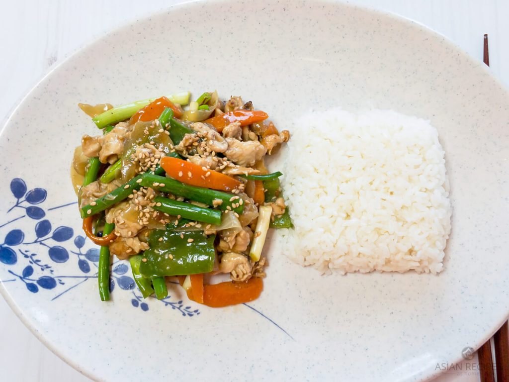Easy Asian chicken and vegetable stir-fry plated with freshly steamed white rice.